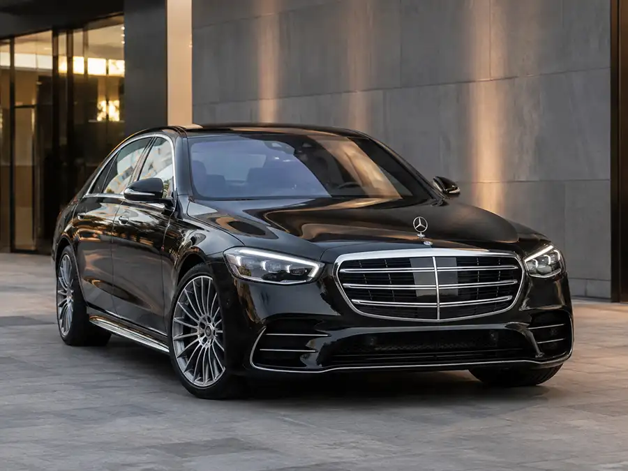 Black luxury vehicle outside an elegant venue at night