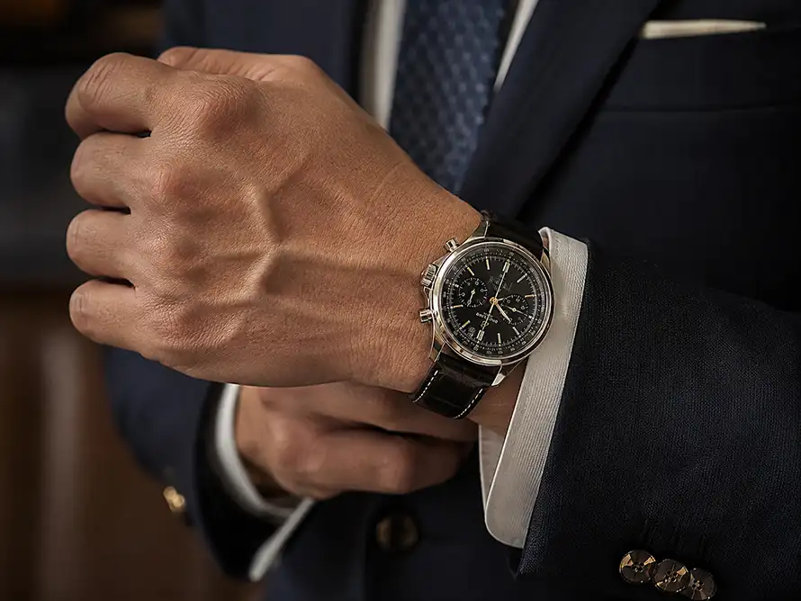 Guest adjusting a luxury watch with a formal jacket
